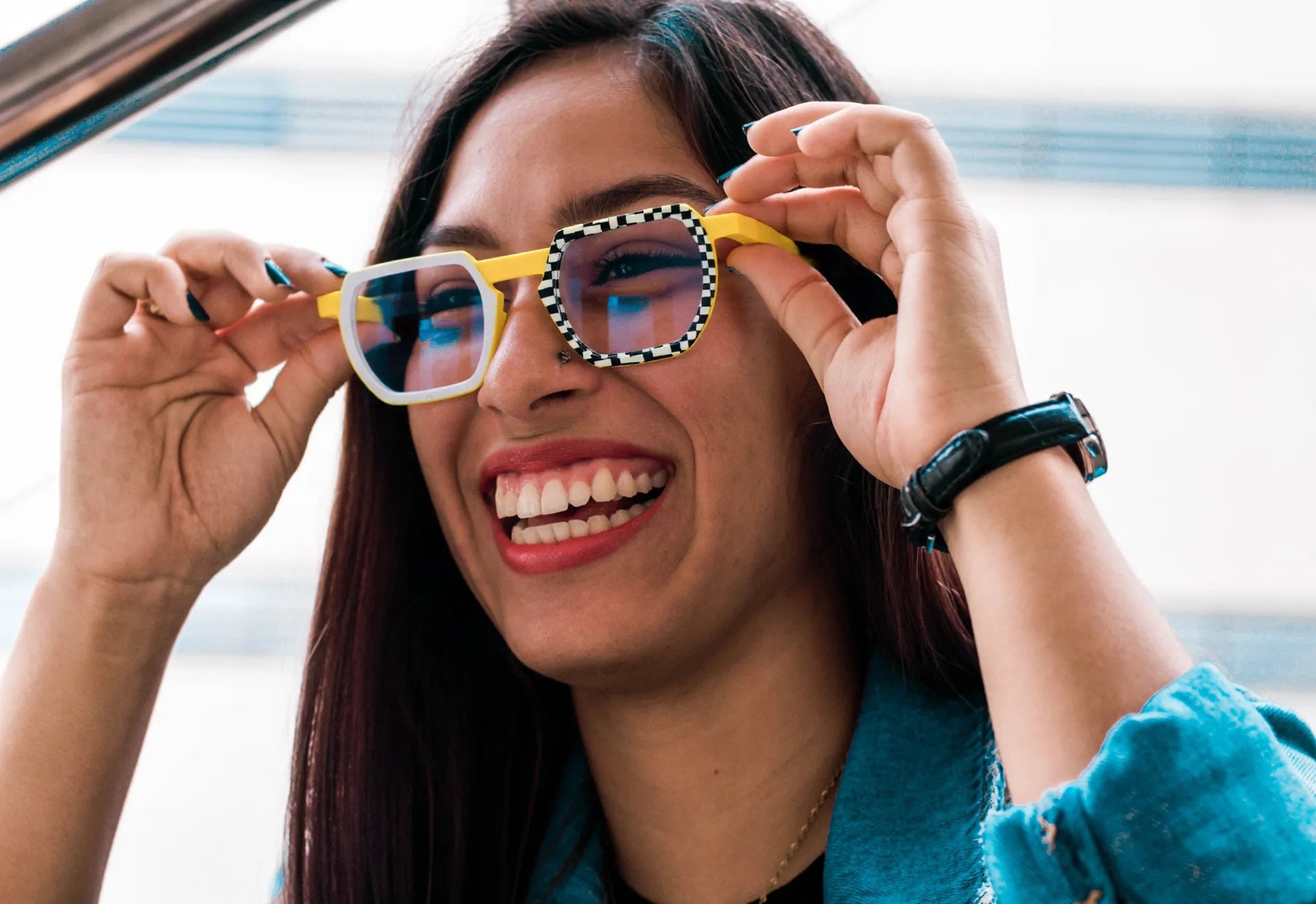 Smiling woman wearing colorful VoyueLens™ yellow glasses with blue lenses and checkered rims